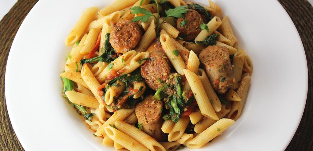 A plate of noodles with Premio sausage, cilantro, and more